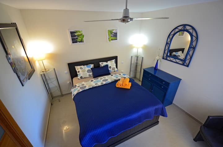 Quarto com cama de casal e acesso à varanda