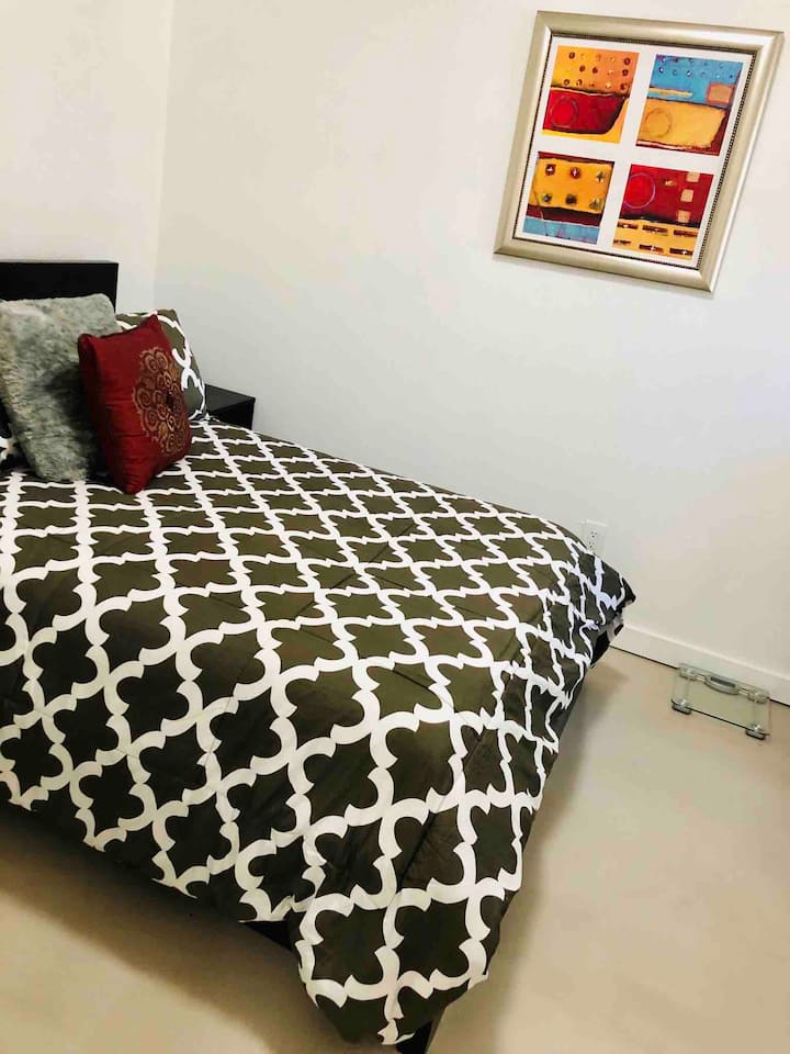 غرفة نوم 1 في الطابق السفلي بسرير كامل الحجم وأرضية خرسانية جميلة