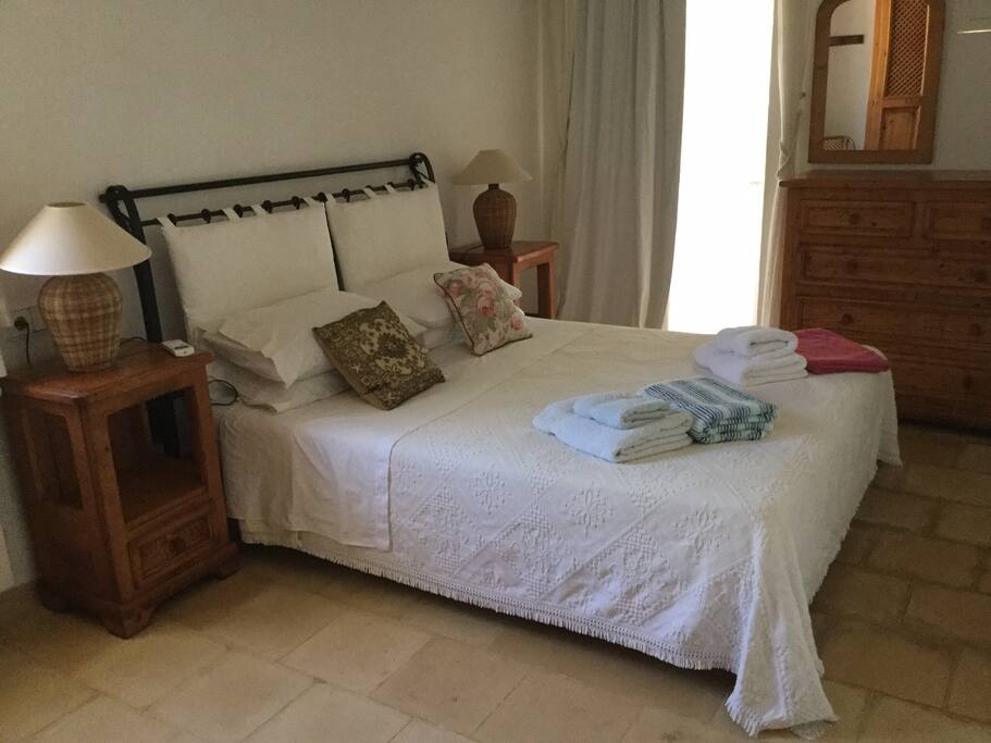 The double bedroom has doors leading to the outside terrace and a cool breeze gives the room a pleasant ambience.