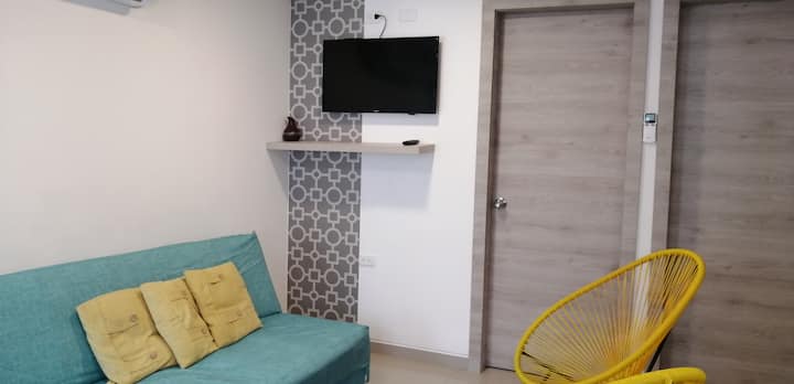 Un salon dans un mini-appartement avec Internet,  climatisation, TV et  Netflix.