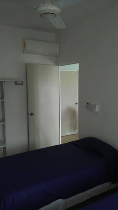 Recámara principal con cama matrimonial, clóset, lámpara de noche, ventilador y aire acondicionado.