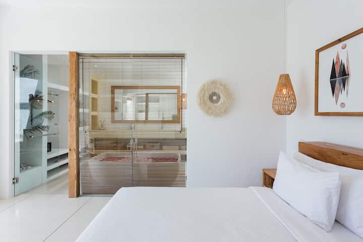 Svijetla i udobna spavaća soba s privatnom kupaonicom i kadom savršenom za opuštajuću kupku s cvijećem. Uživajte u umirujućem pogledu na bazen i vrt.