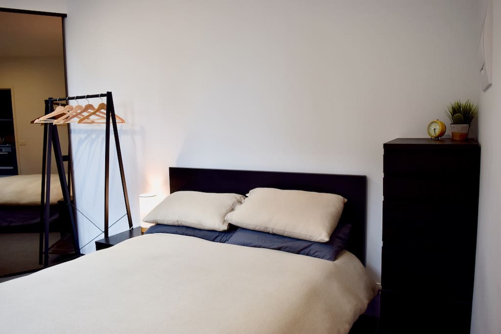 A bright room with double bed, external and internal hanging space.