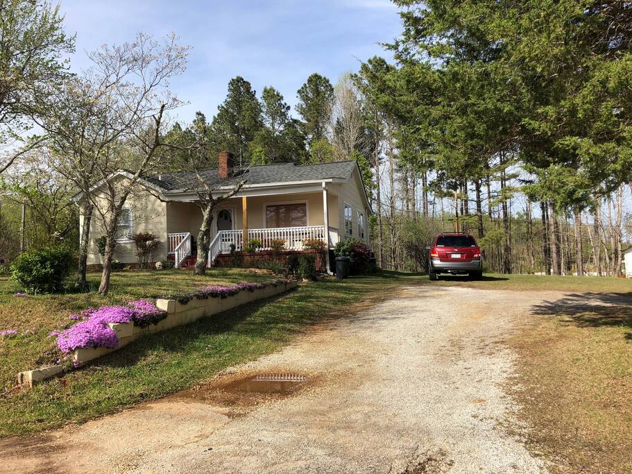 Small home with driveway along with a small field for trailer parking or multiple vehicles.