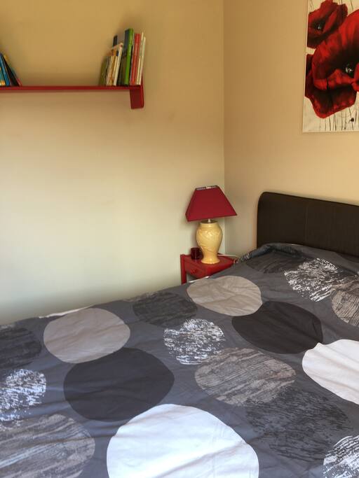 Avec une table de chevets et une étagère