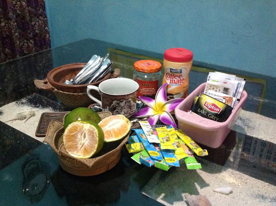 Breakfast at the table with simple local fruit, coffee, and tea