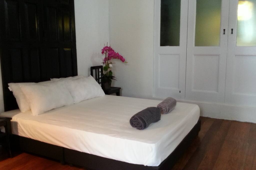 Queen size bed with pillows, bedsheet, blanket and towel