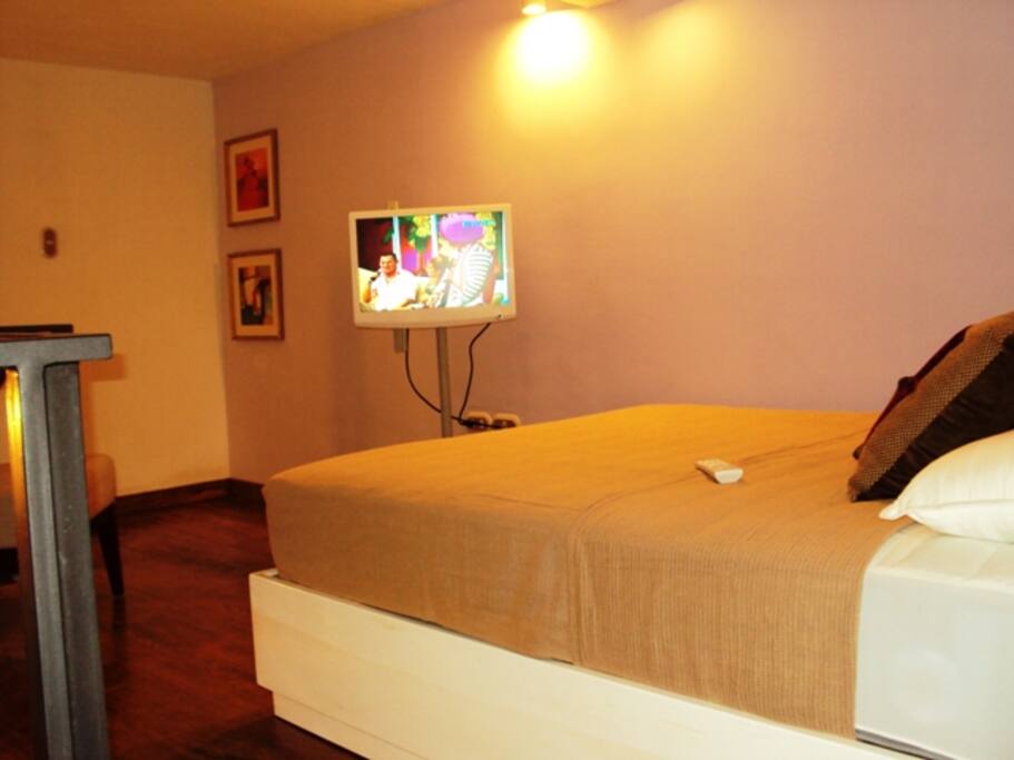 La cama está en un mezzanine de cálida madera