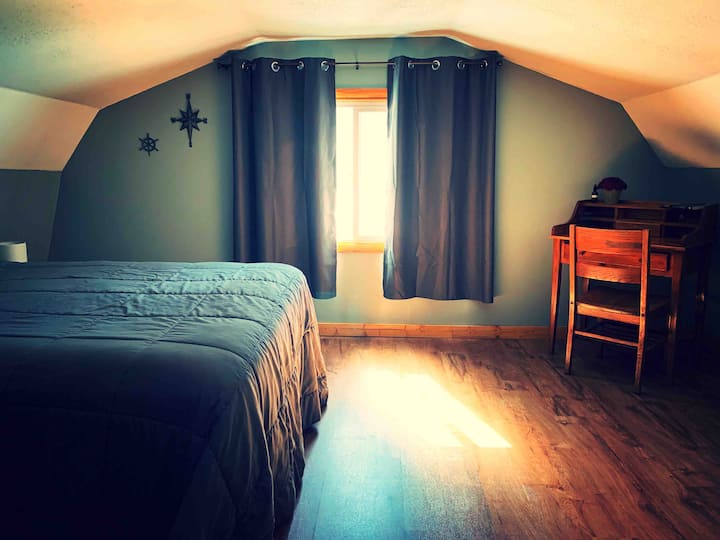 غرفة النوم الرئيسية/الأمامية. سرير بحجم كبير ومكتب كتابة صغير.