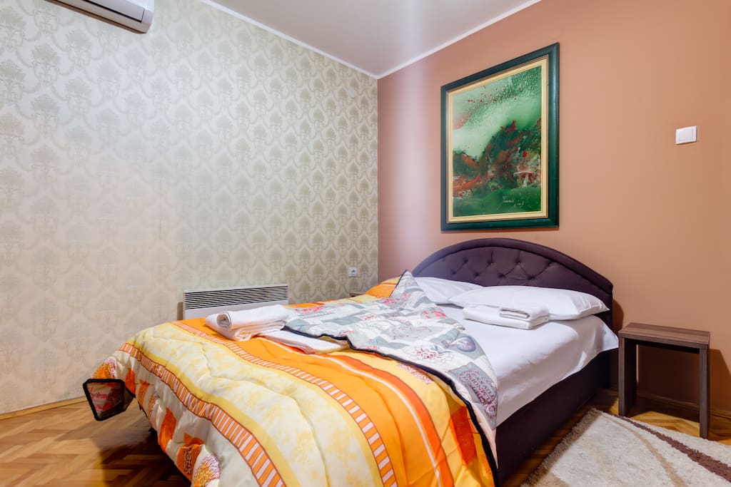 Double bed with night stands is in the bedroom. Wall paint and decorations should be calming, so our guests can fall asleep easily.