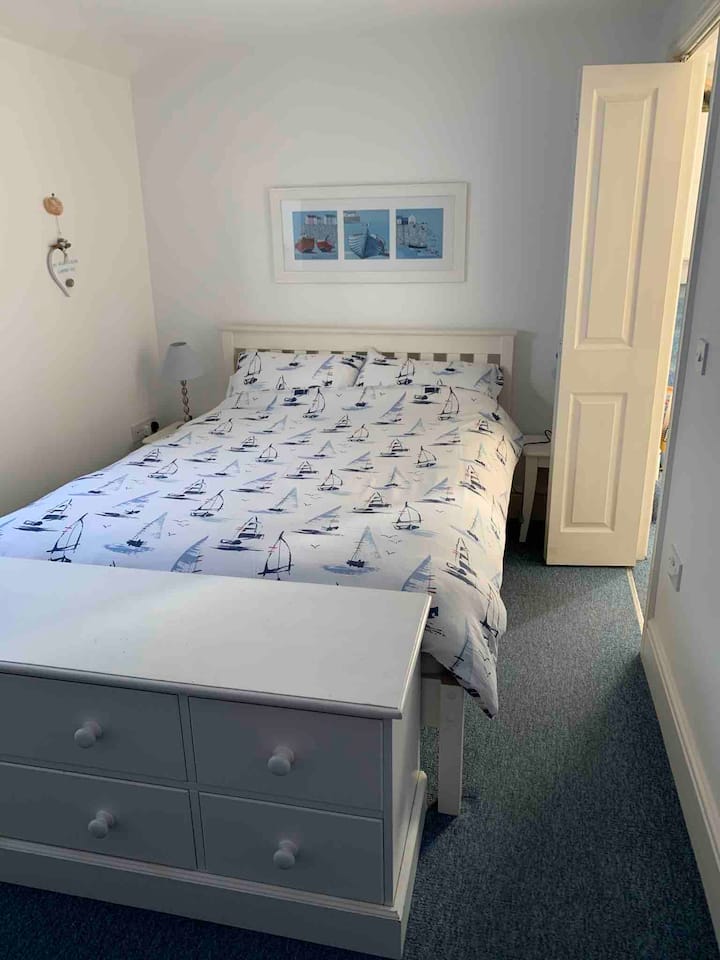 غرفة النوم 1 بسرير مزدوج، وطاولتان جانبيتان، وخزانة أدراج، ووحدة صغيرة.