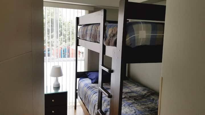 Dhoma e tretë e gjumit me krevate, dollap dhe stendë nate.