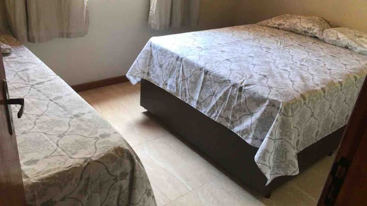 O segundo quarto tem uma cama de casal e uma de solteiro.