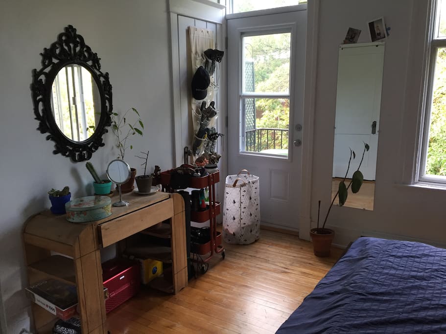 Chambre principale avec balcon et grande fenêtre.