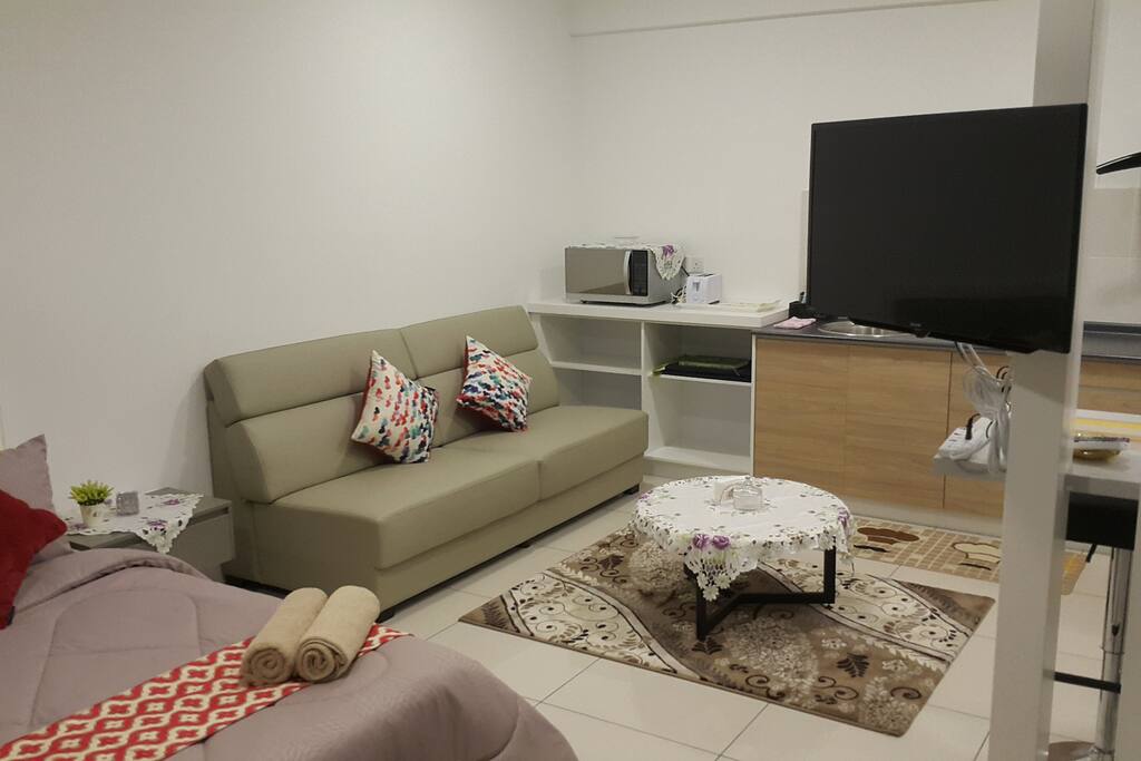 A comfortable sofa with 2 throw cushions and a tea table.