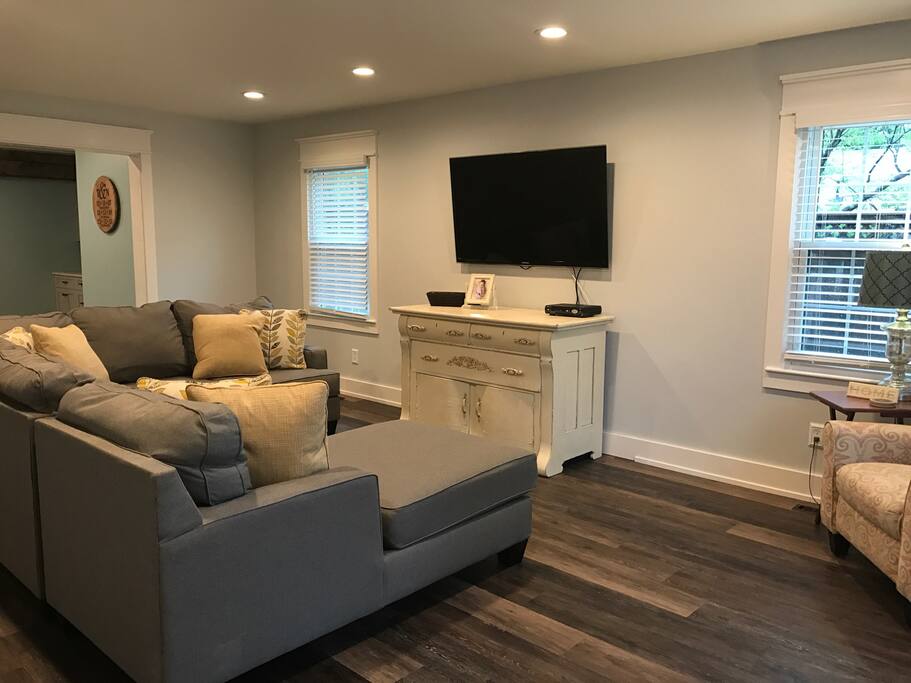 Spacious living room with TV and a couch.