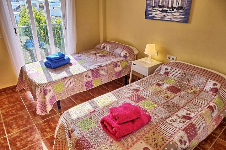 Bedroom two with twin beds and patio doors onto terrace with sea views. All the bedrooms have air conditioning, ceiling fan, window shutters and wardrobe.