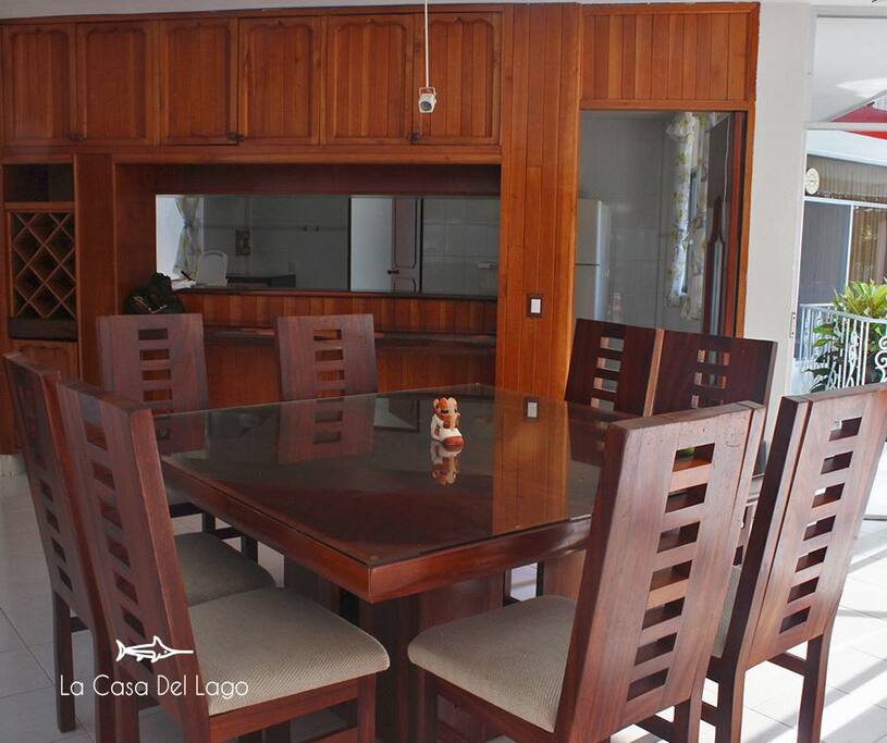 El comedor se conforma de una mesa cuadrada con 8 sillas, ideal para usted y sus seres queridos. La cocina dispone de refrigerador y congelador, una estufa con 5 quemadores y horno, un fregador y un horno de microondas.