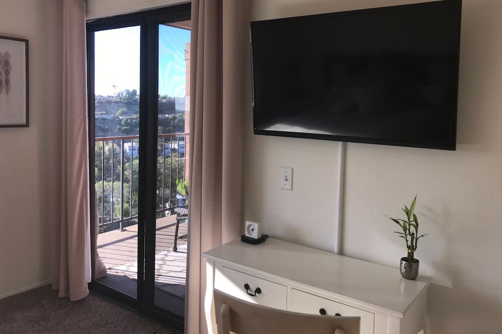 Apple TV and work desk. Sliding glass door leads to balcony.