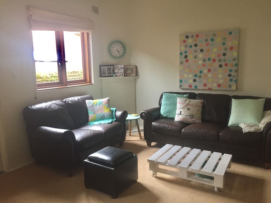 Large lounge room next to kitchen, includes one 3 seat sofa, 1 two seat sofa and 2 chairs. TV with cable and an apple box. Bookshelf of books and drawers filled with games for all ages.