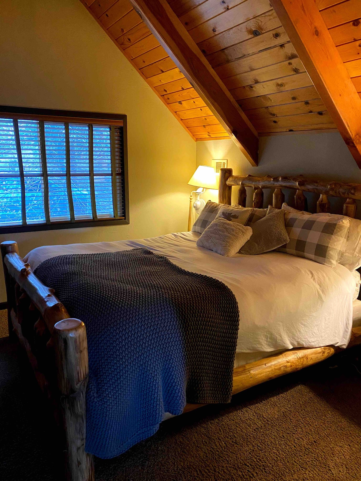 Dormitorio principal con cama tamaño king y techo de madera alpina