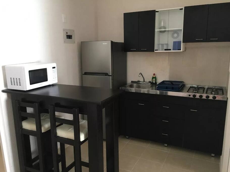 Cocina equipada con todo lo requerido y barra con bancos