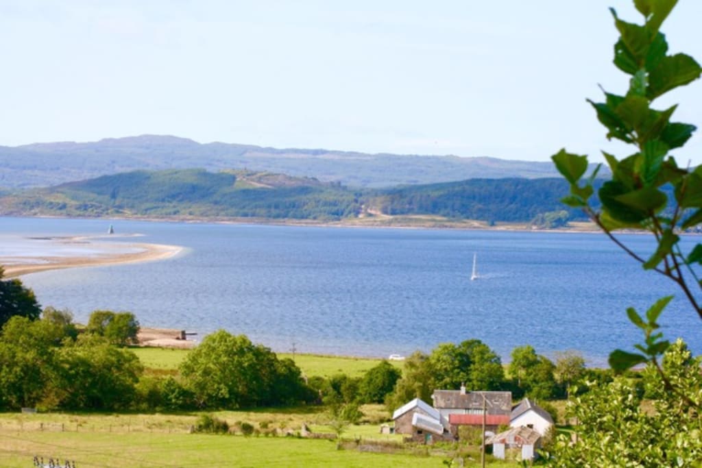 Looking west across the roof tops of Kilail Farm to Loch Fyne, over the Otter Ferry Spit at low tide .