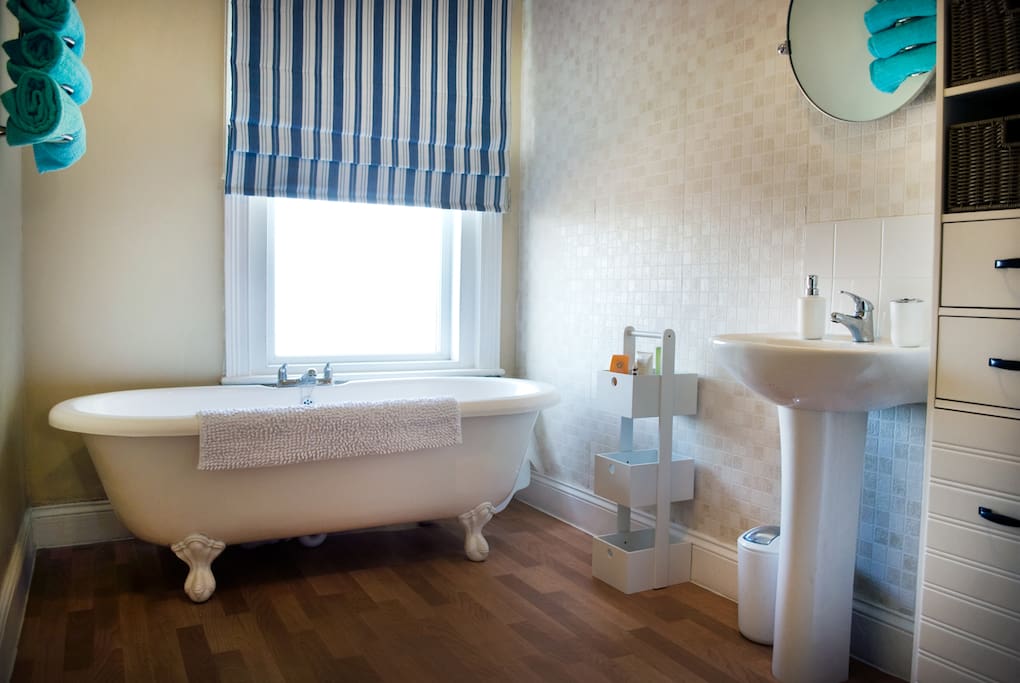 bathroom with roll top bath, separate shower and sink. Towels are provided and spare toiletries are available.