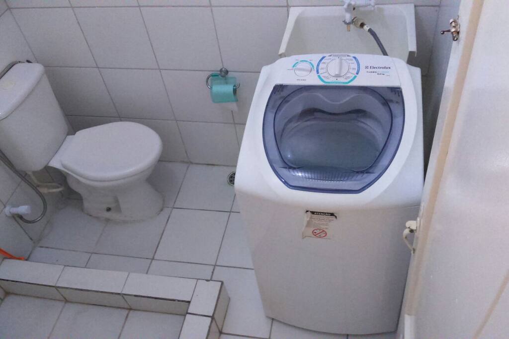 Banheiro grande com máquina de lavar roupas.