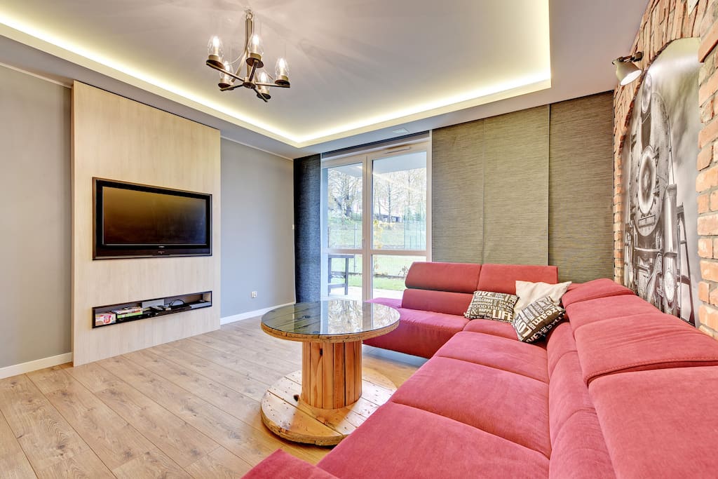 Salon z rozkładana sofa i wyjściem na ogród