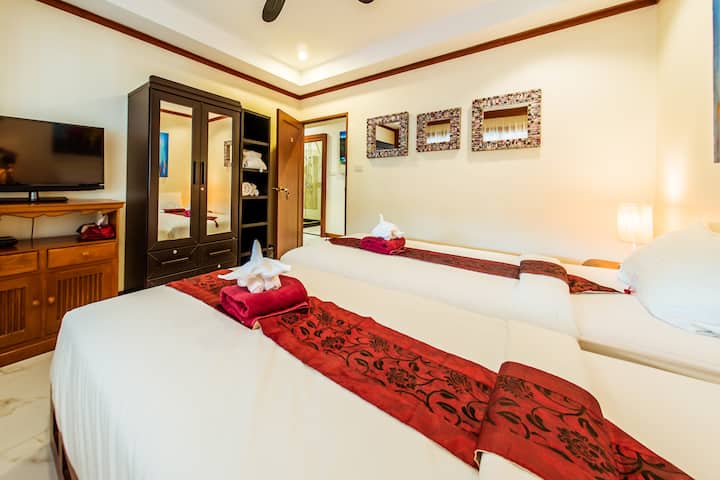 توجد غرفة نوم أصغر مع سريرين مزدوجين في الخارج مقابل غرفة النوم مباشرة 