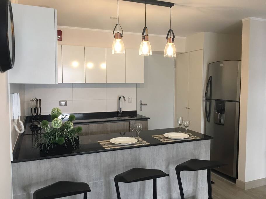 Cocina tipo kitchenette con tablero de cuarzo color negro.