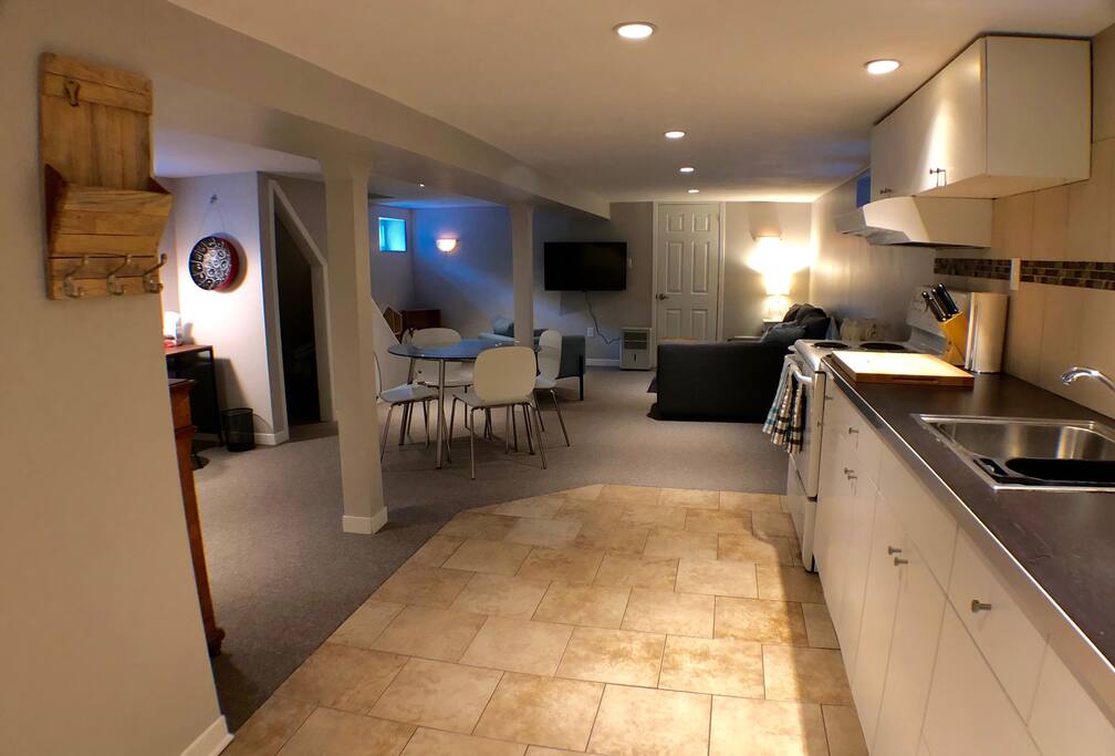 The main space is open concept, with kitchen, dining area, living room, desk nook, and kid's toy corner.