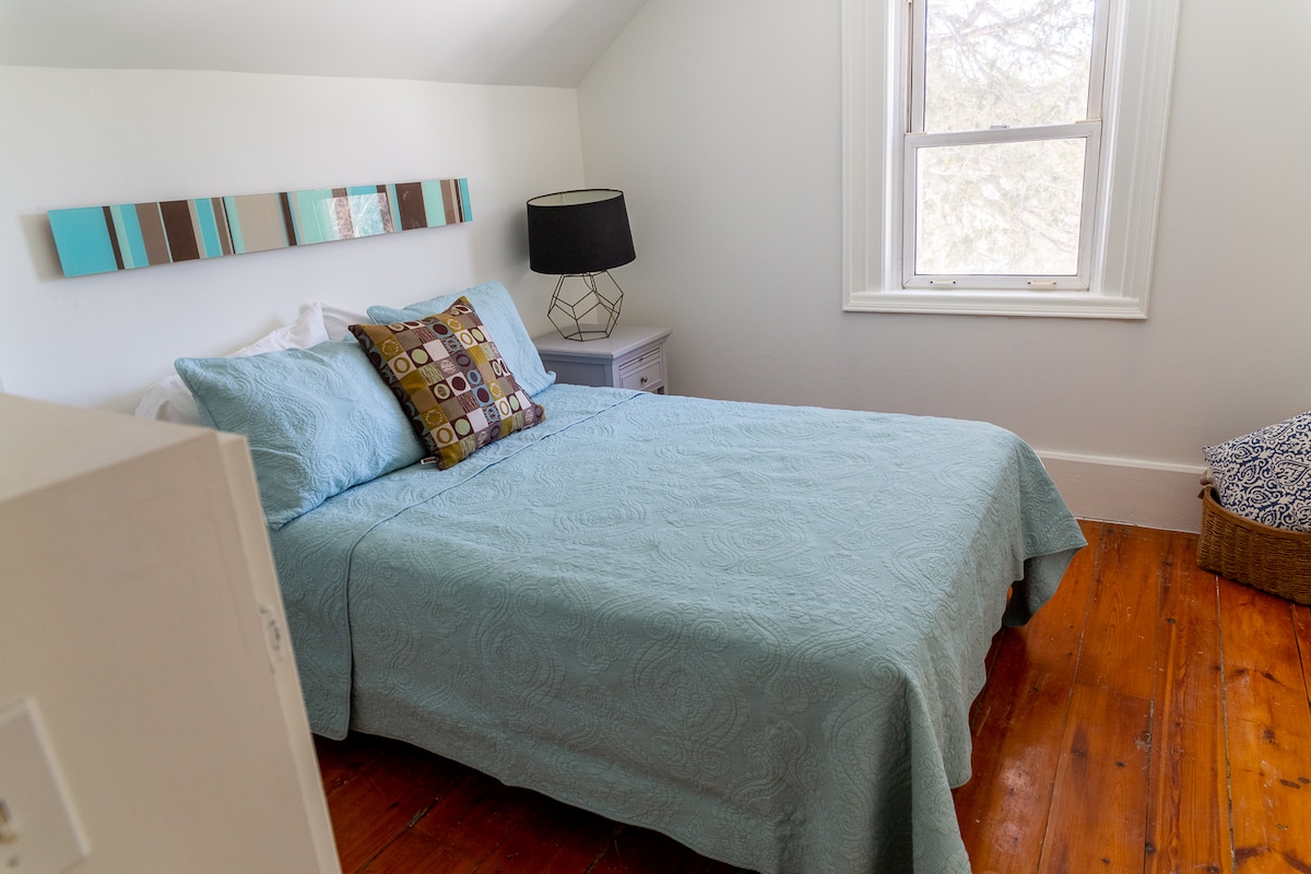 Dormitorio con cama doble y ventilador de techo.