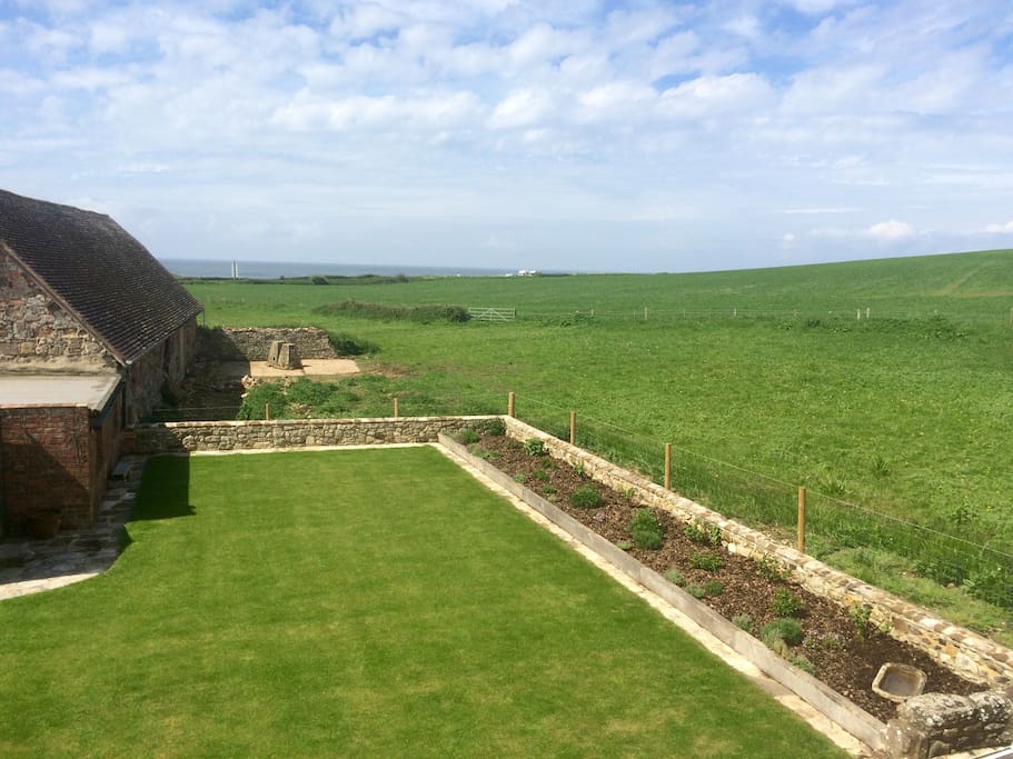Enclosed south facing rear garden bordered by open fields overlooking the sea.