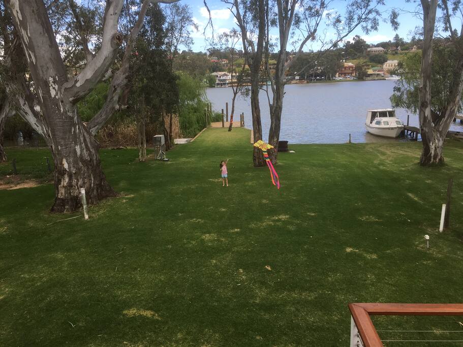 Grassed area looking from river side balcony with large jetty for boat mooring. Large reserve next door with boat ramp