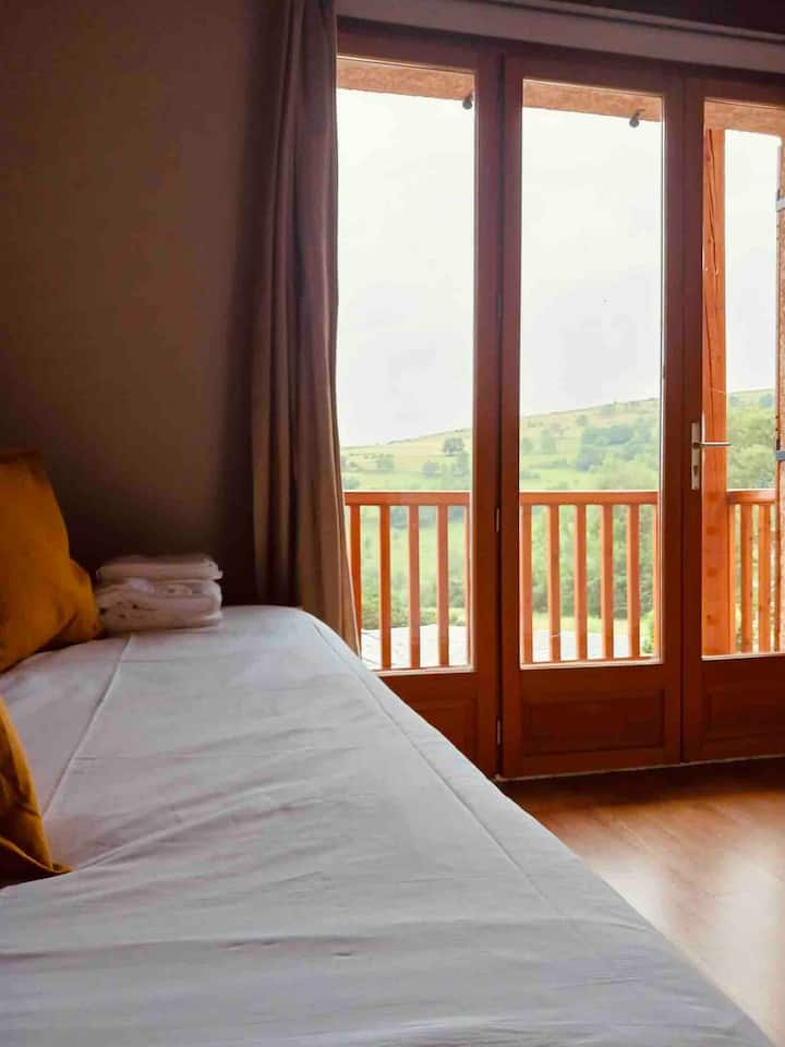 Spavaća soba s bračnim krevetom koji se može ukloniti i izlazom na balkon s kojeg se pruža spektakularan pogled.