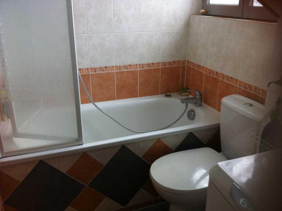 Salle de bain avec baignoire et lave linge