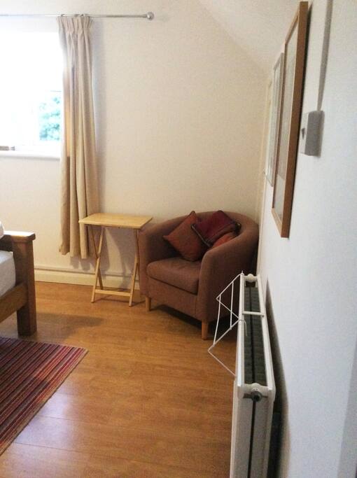 A comfy armchair with small desk for laptop work.