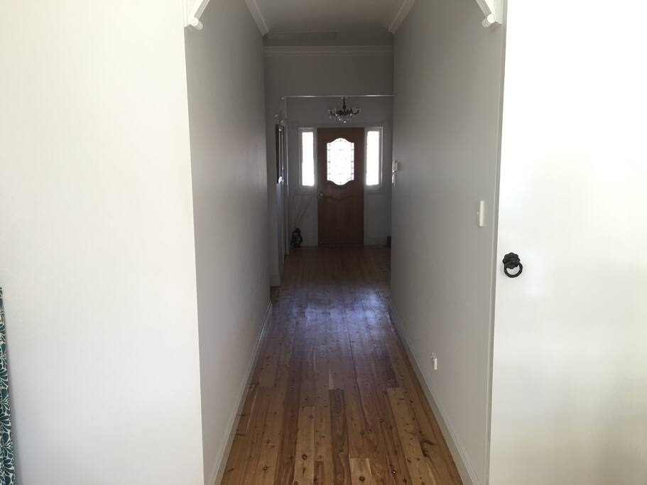 Hallway to front door , bedrooms and cosy fireplace
