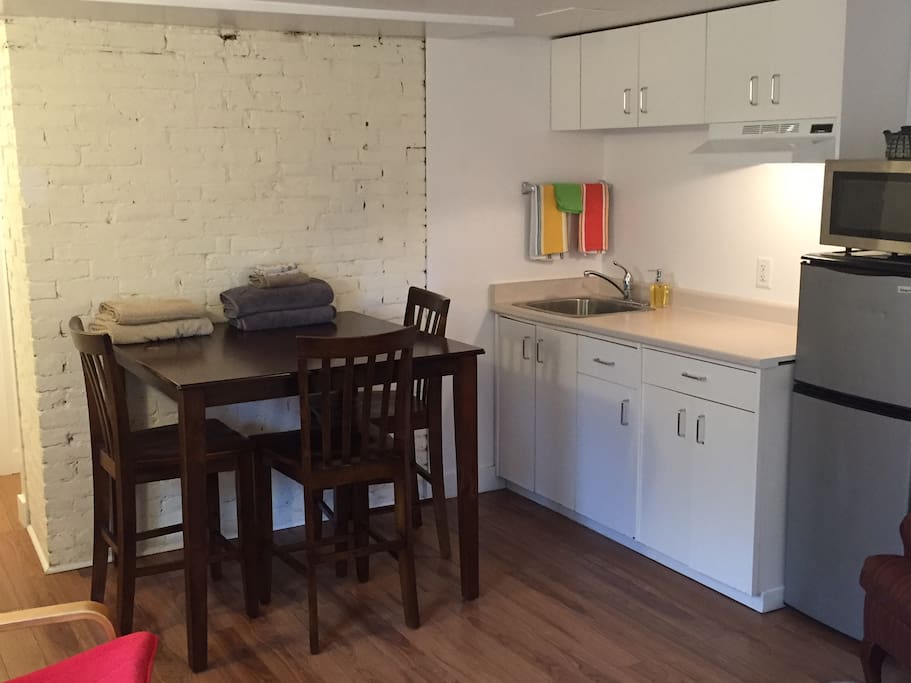 Fully stocked kitchenette: kettle, counter top plug in 2 stove burner, toaster oven, microwave, 3/4 size fridge; dishes; pots & pans; high table for eating or working.