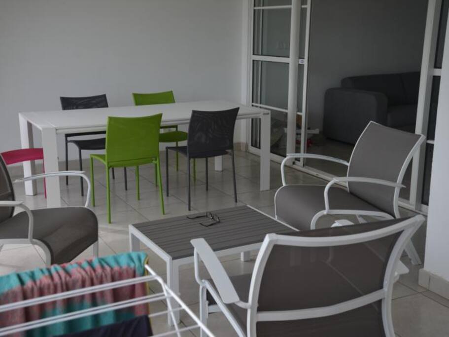 Terrasse équipée d'un salon d'extérieur et d'un table de S à M pour 8 personnes