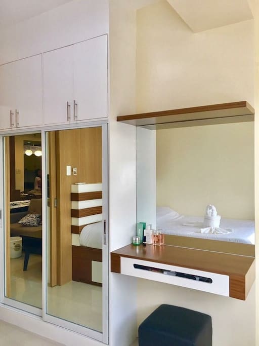 Title: BED ROOM (Opposite to bed wall)
Description: Sliding mirrored door closet, desk with mirror and stool.