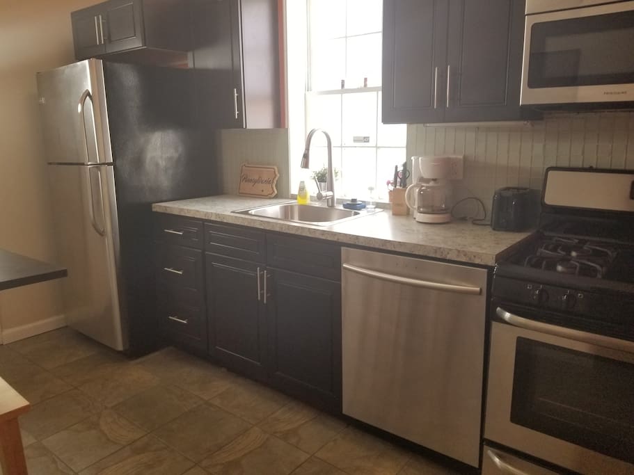 Kitchen view, new stainless steal fridge, dishwasher, sink, stove, and microwave.