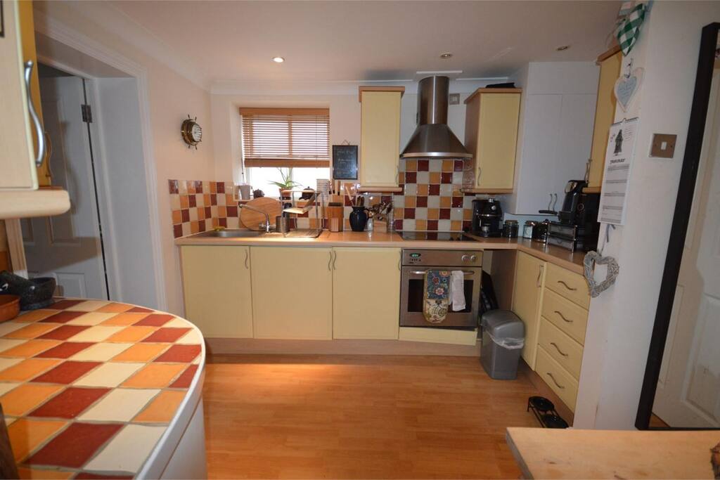 This is the kitchen with built in dishwasher and washer/dryer. Also oven, microwave and electric hob. Tea and coffee are in the cupboard