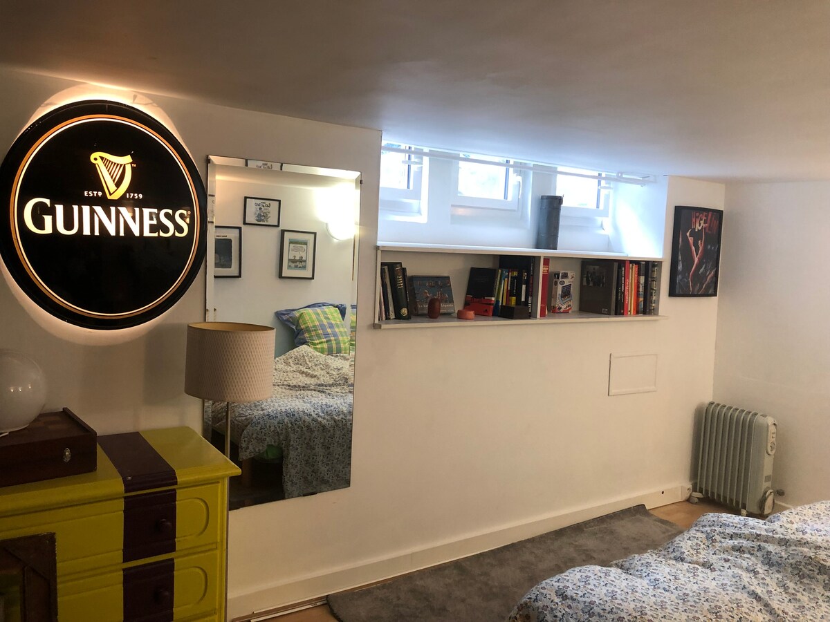 Habitación entre el suelo que consta de dos camas individuales, almacenamiento (cómoda, perchero), sofá de dos plazas 