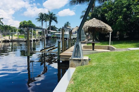Modern Tropical pool home on water, dock, tiki hut