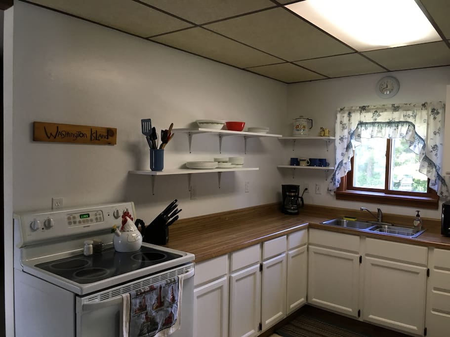 Full size refrigerator, stove, and coffee and tea pot.