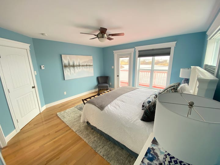 غرفة نوم رئيسية بسرير كبير وإمكانية الوصول إلى سطح علوي