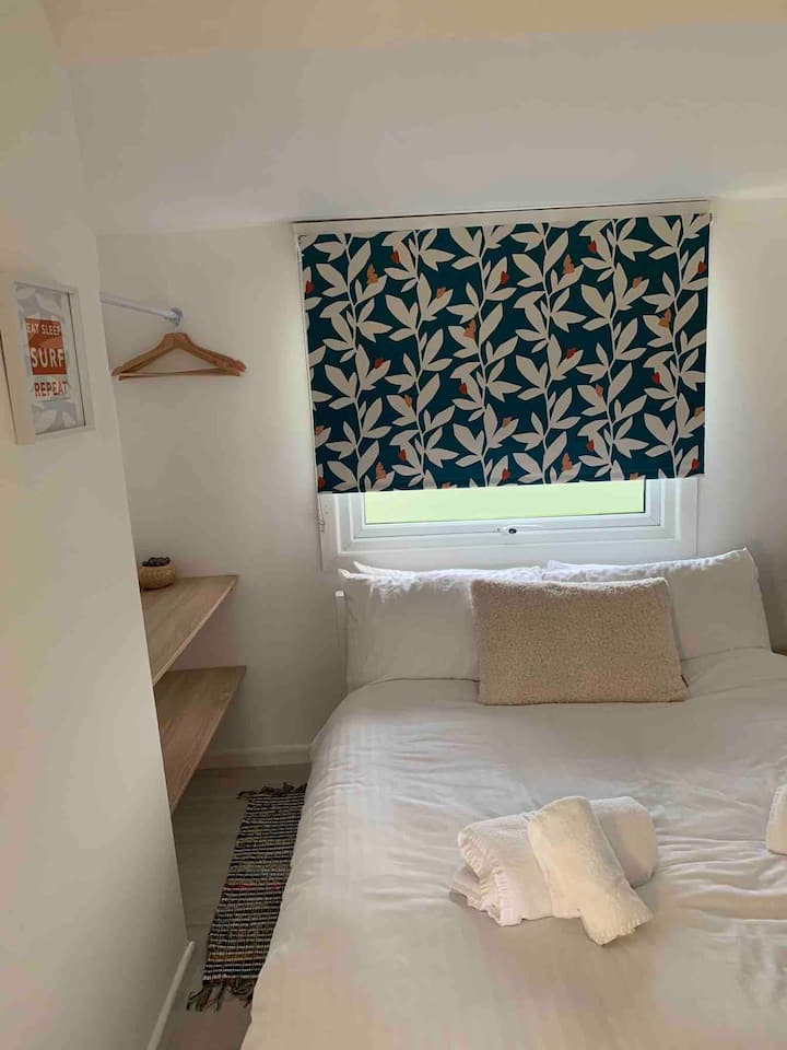 Second bedroom has a double bed. shelving and hanging space.